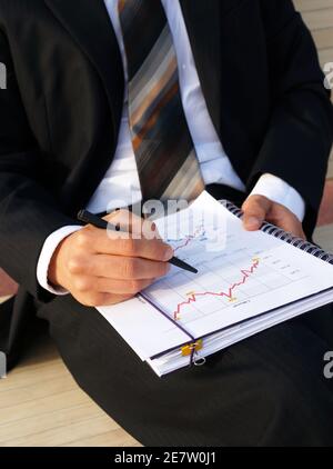 Businessman wertet Unternehmensdaten aus und prüft Diagramme und Werte Stockfoto