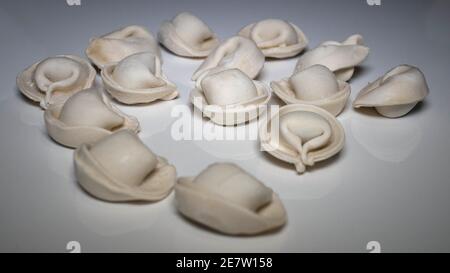 Die Knödel sind roh, nicht gekocht, auf dem weißen Küchentisch Stockfoto