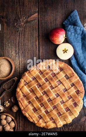 Hausgemachtes Dessert, altmodischer Gitterkrustenkuchen mit geriebener Apfel- und Walnussfüllung, bestreut mit Granulatzucker und Zimt auf rustikalem Holz Stockfoto