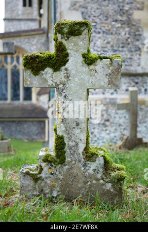 Grabsteinkreuz in einem Friedhof, alter Grabstein mit Moos, UK Stockfoto