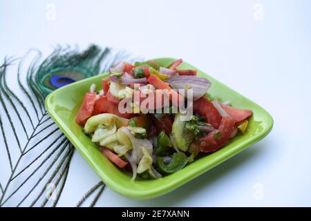 Indischer authentischer Salat, bekannt als Kachumbar Salat, zubereitet aus frisch gehackten Zwiebeln, Tomaten, Gurken, Koriander und grünem Chilly. Gesprickelt mit lemo Stockfoto