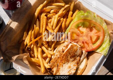 Frisch gegrillter Fisch-Sandwich mit Salat und einer Tomatenscheibe. Stockfoto