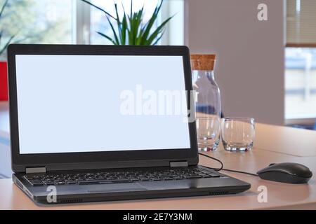 Schwarzer pc-Laptop mit der Maus auf einem Holzschreibtisch Im Büroraum Stockfoto