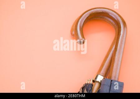 High-Angle-Aufnahme von zwei Schirmen mit Holzgriffen isoliert Auf einem orangefarbenen Hintergrund Stockfoto