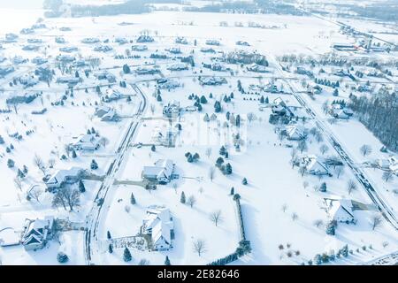 Fliegen über große Häuser mit großen Yards in einem Vorort direkt nach einem frischen Schneefall Schnee. Stockfoto