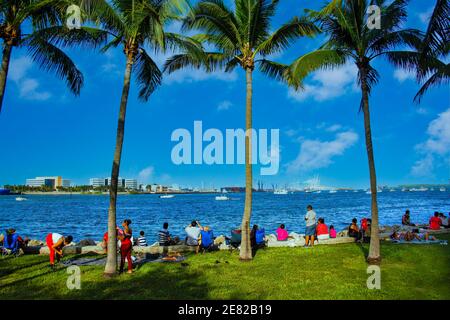 Menschen genießen die Uferpromenade und einen Blick auf den Hafen von Miami aus Bayfront Park. Stockfoto