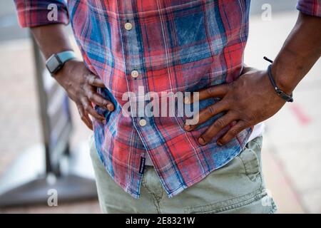 Nahansicht der schwarzen männlichen Hände an den Hüften. Stockfoto