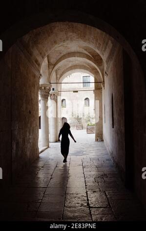 Bari, Italien - 08. Juli 2013: Eine junge Frau überquert die hohen Bögen, die in den Innenhof des normannisch-schwäbischen Schlosses in der Altstadt von Bari führen. Die Ca Stockfoto