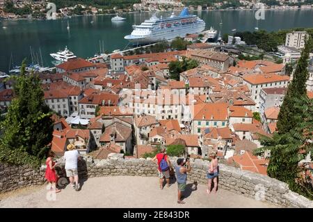 Kotor, Montenegro - 18. Juli 2013: Touristen mit Blick auf die Skyline von Kotor von über der Festung. An den Ufern der Bucht von Kotor ist eine Kreuzfahrt-shi vertäut Stockfoto