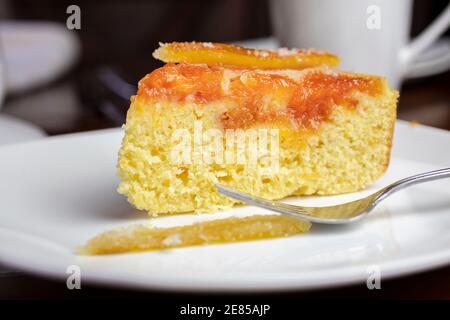 Kandierte Orange umgedrehten Kuchen mit Orange und Zitrone gemacht Spült auf einer weißen Keramikplatte Stockfoto