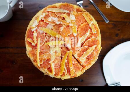 Kandierte Orange umgedrehten Kuchen mit Orange und Zitrone gemacht Spült auf einer weißen Keramikplatte Stockfoto