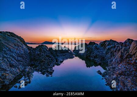 Wunderschöne Sonnenaufgang oder Sonnenuntergang Seeslandschaft über andaman Meer in Phuket Thailand Epische Morgendämmerung Meereslandschaft mit Felsen in der Langzeitbelichtung Vordergrund im Stockfoto