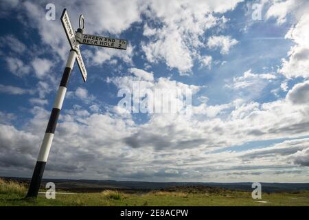 Altmodisches britisches Straßenschild in der Nähe von Goathland im North York Moors National Park, das den Weg nach Green End, Beck Hole und Whitby anzeigt Stockfoto