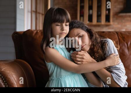 Nahaufnahme fürsorgliches kleines Mädchen tröstend, umarmt depressive Mutter Stockfoto