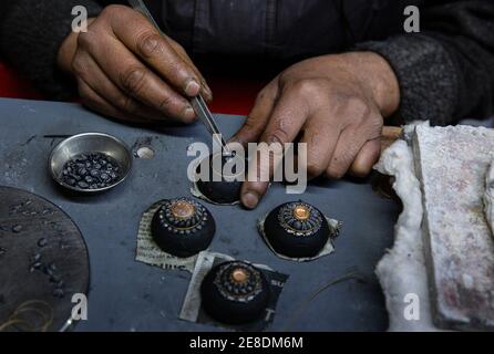 Srinagar, indisch kontrolliertes Kaschmir. Januar 2021. Ein Handwerker arbeitet an einem Schmuckstück in einer Werkstatt in Srinagar, der Sommerhauptstadt des von Indien kontrollierten Kaschmir, 30. Januar 2021. Quelle: Javed Dar/Xinhua/Alamy Live News Stockfoto