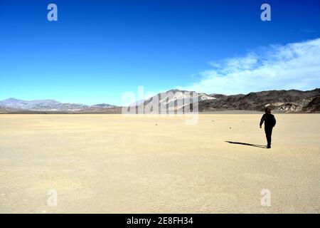 Einzelperson steht auf der Rennstrecke Playa im Death Valley Nationalpark - ein Mann erforscht die Segelsteine, ein Phänomen in der Wüste, Stockfoto