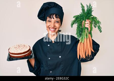 Schöne brunettte Frau Koch Kochen Karottenkuchen lächelnd mit einem glücklichen und kühlen Lächeln auf Gesicht. Zeige Zähne. Stockfoto