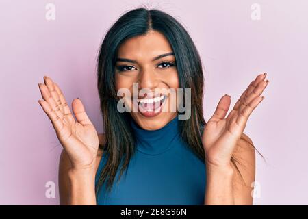 Junge lateinische transsexuelle Transgender Frau mit Händen über Gesicht feiert verrückt und erstaunt für den Erfolg mit offenen Augen schreien aufgeregt. Stockfoto