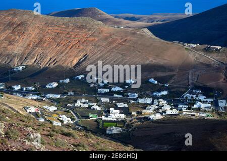 Blick vom Berg Atalaya de Femes auf die kleine Stadt Femés. Lanzarote, Kanarische Inseln, Spanien. Die Bergkette Los Ajaches im Hintergrund. Stockfoto