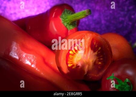 Frische rote Paprika und Tomaten auf einem Haufen. . Einen Halben Schnitt. Hell Gebürstet. Stockfoto