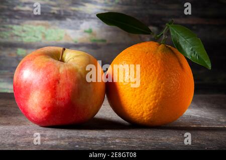 Herbst Stillleben von Orange und Apfel. Makrofoto von auf Holztisch mit verfallener Hintergrund. Aufgenommen mit Spotlight in Studio Stockfoto