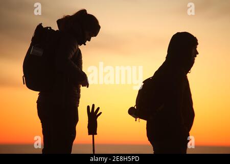 Schierke, Deutschland. Januar 2021. Die Silhouette zweier Brocken-Besucher sticht im Licht der aufgehenden Sonne hervor. Der Brocken begrüßte seine Besucher am Sonntag mit einer außergewöhnlichen Fernsicht. Das sonnige Wetter zog viele Wanderer auf den Harz Gipfel. Die Temperaturen auf dem Brocken lagen im zweistelligen Minusbereich. Quelle: Matthias Bein/dpa-Zentralbild/dpa/Alamy Live News Stockfoto