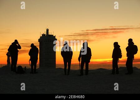 Schierke, Deutschland. Januar 2021. Besucher warten auf dem Brocken auf den Sonnenaufgang. Mit einer außergewöhnlichen Fernsicht begrüßte der Brocken seine Besucher am Sonntag. Das sonnige Wetter zog viele Wanderer auf den Harz Gipfel. Die Temperaturen auf dem Brocken lagen im zweistelligen Minusbereich. Quelle: Matthias Bein/dpa-Zentralbild/ZB/dpa/Alamy Live News Stockfoto