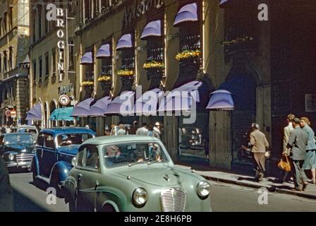 Ein Blick auf die Via del Corso, Rom, Italien im Jahr 1955. Die belebte Straße war (und ist immer noch) eine Hauptstraße im historischen Zentrum von Rom. Heute ist der Corso eine wichtige Einkaufsstraße und auch ein beliebter Ort für die Passeggiata, den Abendspaziergang für Einheimische zu sehen und andere zu sehen. Heute ist ein David Naman Herren Bekleidungsgeschäft befindet sich direkt hinter dem No-Left-Turn-Schild. Dieses Bild ist von einem alten Amateur-35mm-Farbtransparenz. Stockfoto