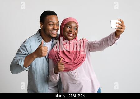 Positives afroamerikanisches Paar, das Selfie auf dem Handy nimmt Stockfoto