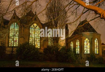 Gouda, Niederlande, 30. Dezember 2020: Licht kommt aus dem Inneren der St. John's Kirche durch die Buntglasfenster Stockfoto