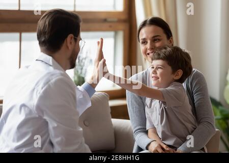 Glücklicher Junge Patient geben hohe fünf zu fürsorglichen Arzt Stockfoto