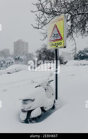 Modernes Motorrad geparkt in der Nähe von Straßenschild und mit dicken bedeckt Die Schicht des Schnees im städtischen Vorort am eiskalten Wintertag Stockfoto
