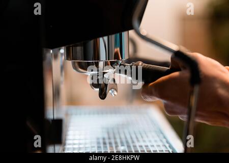 Crop anonyme Barista mit Portafilter in der Kaffeemaschine während der Vorbereitung Trinken Sie im Café Stockfoto