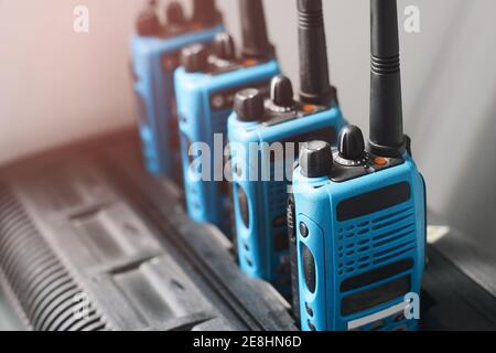 Ein Satz blauer Walkie-Talkies steht in einer Reihe. Ein Gerät zur Übertragung stabiler Funkkommunikation über eine Entfernung. Stockfoto