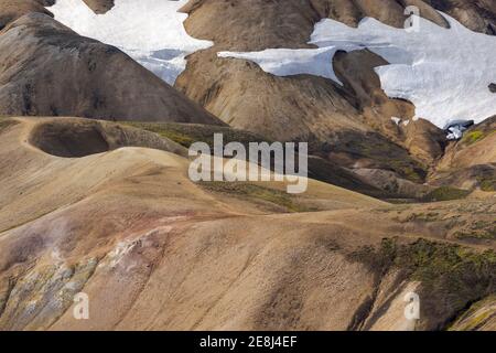 Malerischer Blick auf weite hügelige Land mit trockenem Gras bedeckt Und Schnee in ruhiger Natur bei Tageslicht Stockfoto