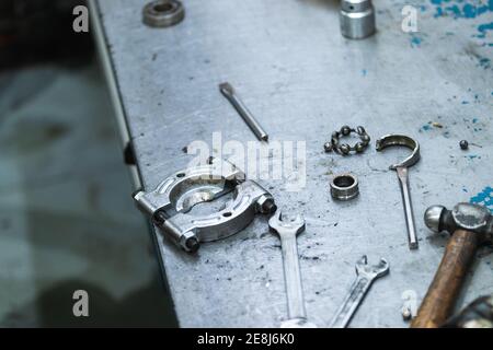 Von oben an das Werkzeug zum Entfernen des Kurbelwellenlagers aus Metall angebracht werkbank mit Schraubenschlüssel und Hammer in der Garage Stockfoto