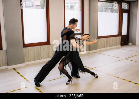 Ein paar Tänzer in eleganter Kleidung, die während des Tanzes im Ballsaal tanzen Klasse in zeitgenössischem Studio Stockfoto
