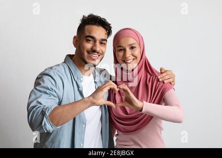 Portrait von romantischen muslimischen Paar macht Herz Geste mit ihren Hände Stockfoto