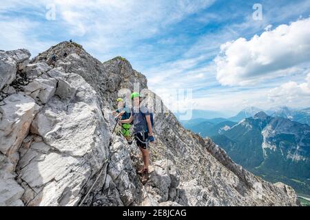 Bergsteiger, die auf einer gesicherten Seilstrecke klettern, Mittenwalder Höhenweg, Karwendelgebirge, Mittenwald, Bayern, Deutschland Stockfoto