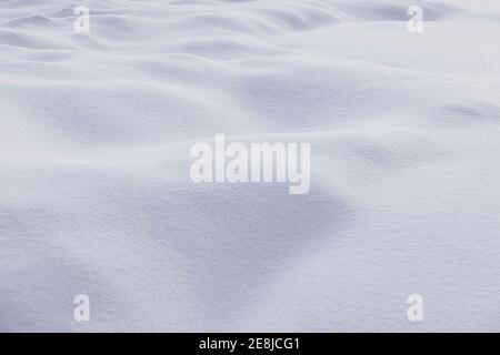 Texturierter Hintergrund des verschneiten Geländes mit weißer holpriger Oberfläche Wintersaison bei Tageslicht Stockfoto