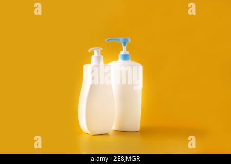Babykosmetikflaschen auf gelbem Hintergrund Stockfoto