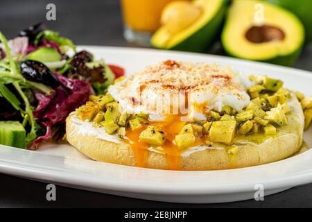 Avocado-Sandwich mit pochiertem Ei. Gehackte Avocado und Ei auf geröstetem Brot für ein gesundes Frühstück oder Snack. Stockfoto