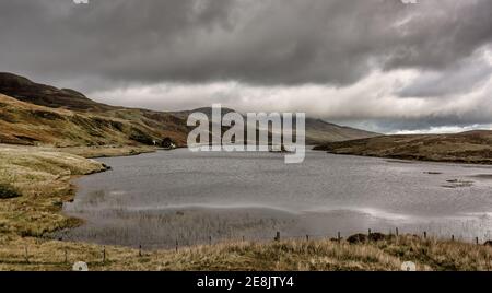 Ein düsterer Morgen auf der Isle of Skye in Schottland. Blick hinunter Loch Fada in Richtung des alten Mannes von Storr, der in niedrigen Wolken bedeckt ist. Stockfoto