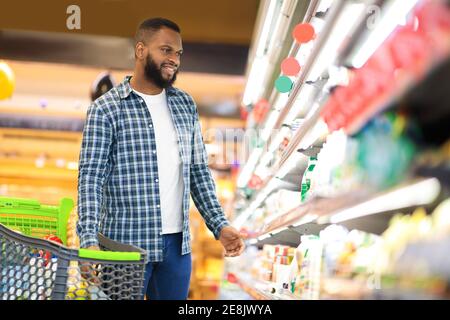 African American Guy Kauf Von Lebensmitteln In Der Nähe Von Regal In Supermarkt Stockfoto