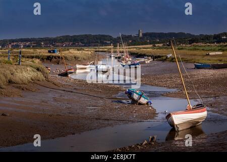 Ebbe im Bach bei Morston mit Blakeney Kirche In der Ferne Stockfoto