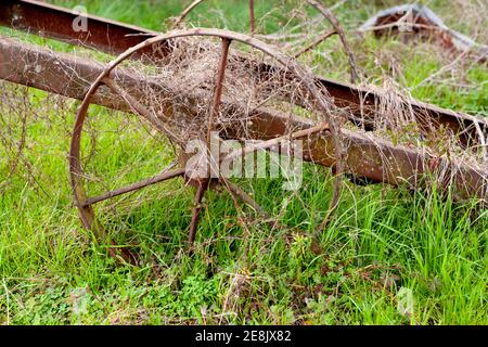 Ein altes eisernes Speichenrad auf dem Rahmen eines Bauerntrailers, in Chrysler, Alabama Stockfoto