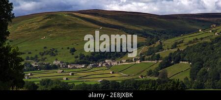 Weite Panoramablick auf das Dorf und Heuwiesen von Gunnerside, Swaledale, Yorkshire Dales Nationalpark. Stockfoto