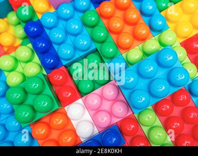 Kinderkonstrukteur in mehreren Farben als abstrakter Hintergrund. Mehrfarbige Blöcke aus der Nähe. Stockfoto