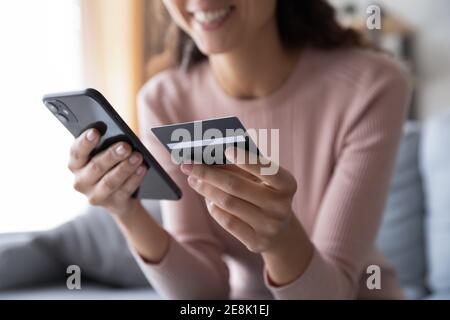 Nahaufnahme lächelnde Millennial Frau mit Smartphone und Kreditkarte. Stockfoto