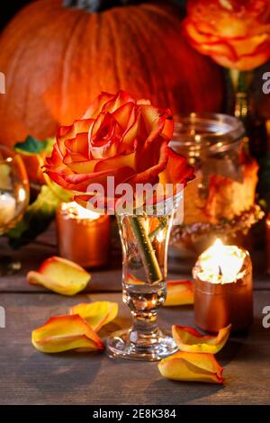 Herbsthochzeit Dekoration mit Kürbissen, Orangenrosen und Kerzen. Partydekor Stockfoto